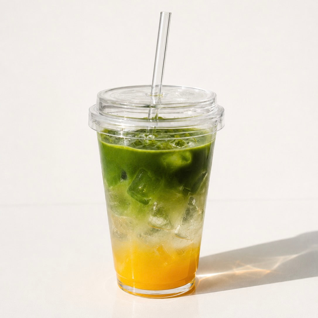 a glas with mango puree, coconut water and matcha on top